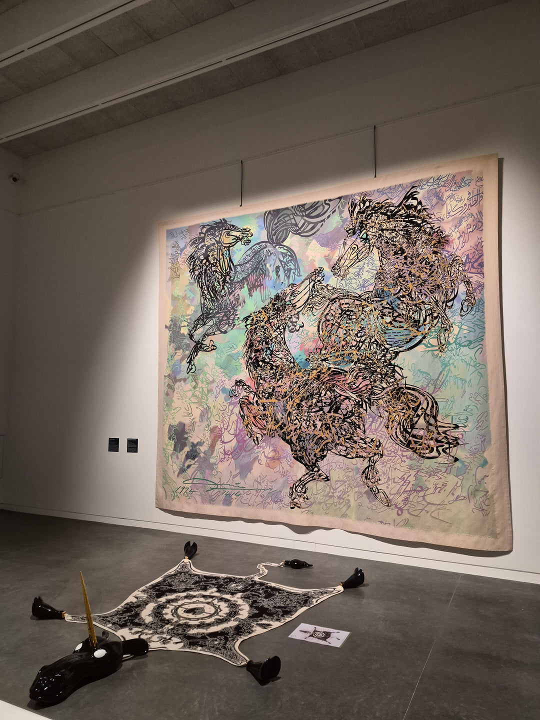 Tapisserie Aubusson accrochée sur tiges de 6 mètres noires fabriquées par Maison Boyer dans un musée avec une grande hauteur sous plafond